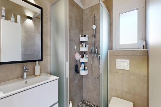 bathroom with vanity, a stall shower, and tile walls
