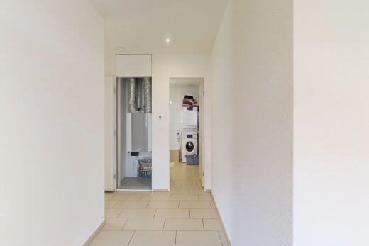 couloir avec light floor, sol en carrelage, tile floor, lave-linge et sèche-linge, et inside property