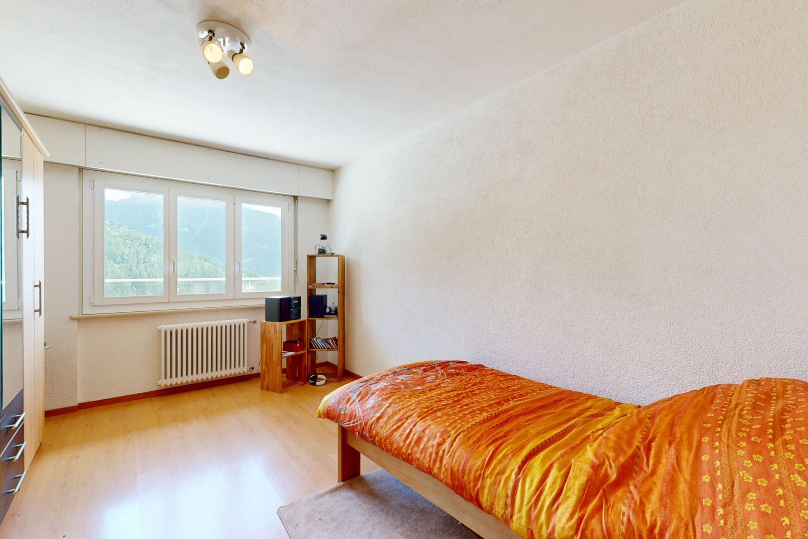 chambre avec radiateur, sol en finition bois, wood finish floor, lumière naturelle, et natural light