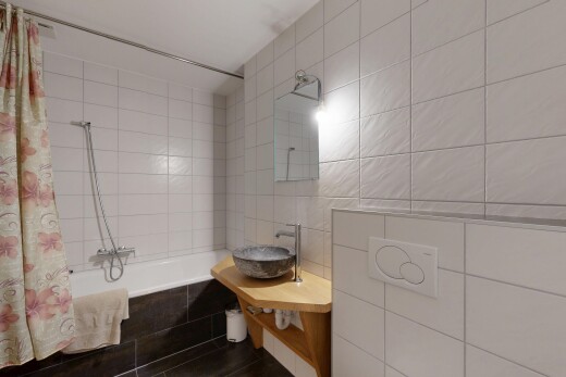 salle de bains avec mur en carrelage, tile wall, miroir, douche-bain combinés, et salle de bain complète