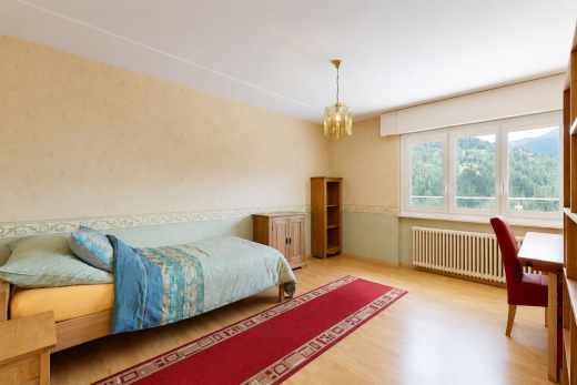 chambre avec sol en finition bois, wood finish floor, lustre remarquable, inside property, et lumière naturelle