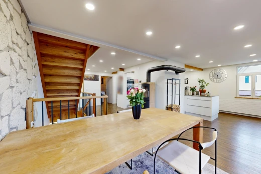 esszimmer mit stone wall, steinwand, treppen, einbauleuchten, und wood finish floor