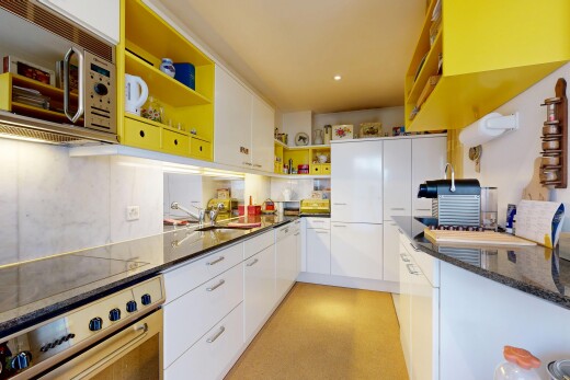 küche mit stein arbeitsplatten, weiße schränke, mikrowelle, ofen, und offene regale