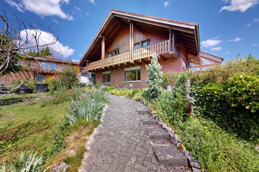 outdoor house featuring a balcony and brick siding