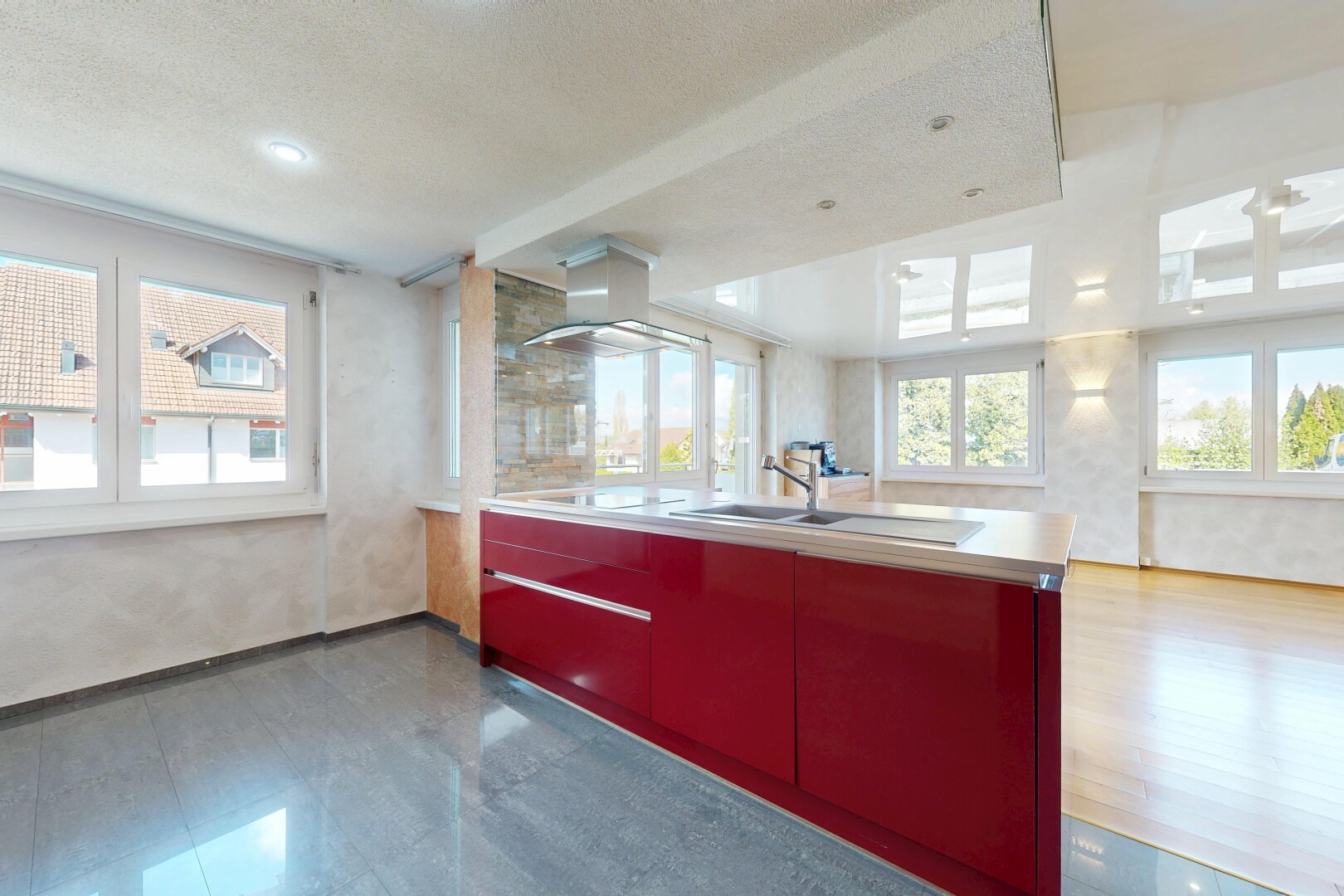 kitchen with healthy amount of natural light, extractor fan, red cabinets, light countertops, and a textured ceiling