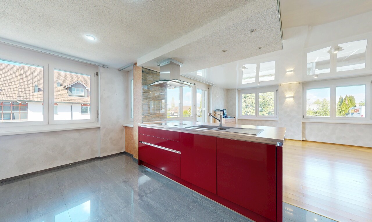 kitchen with healthy amount of natural light, extractor fan, red cabinets, light countertops, and a textured ceiling