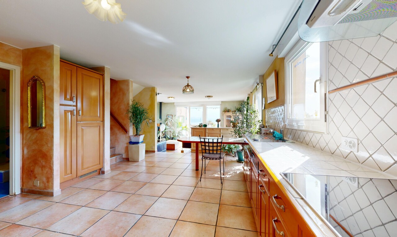 cuisine avec light floor, light countertops, hotte, inside property, et armoires marron moyen