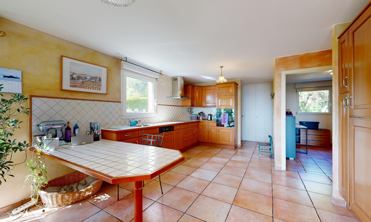cuisine avec péninsule de cuisine, kitchen peninsula, light countertops, hotte, et lumière naturelle