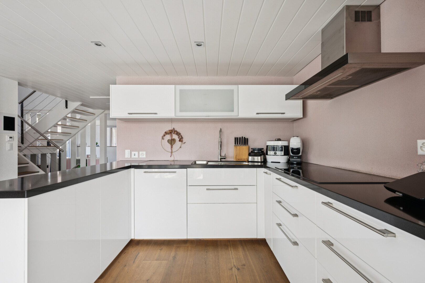 küche mit dunstabzugshaube, treppen, white cabinets, weiße schränke, und dark countertops
