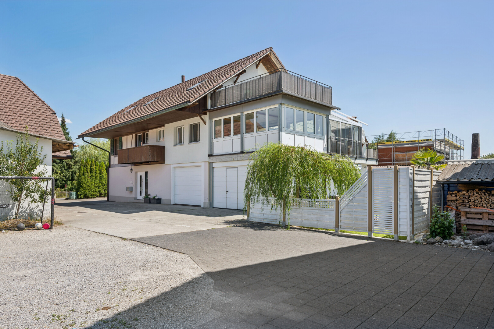 außenansicht mit auffahrt, eingebaute garage, day time, property visible, und stuckverkleidung