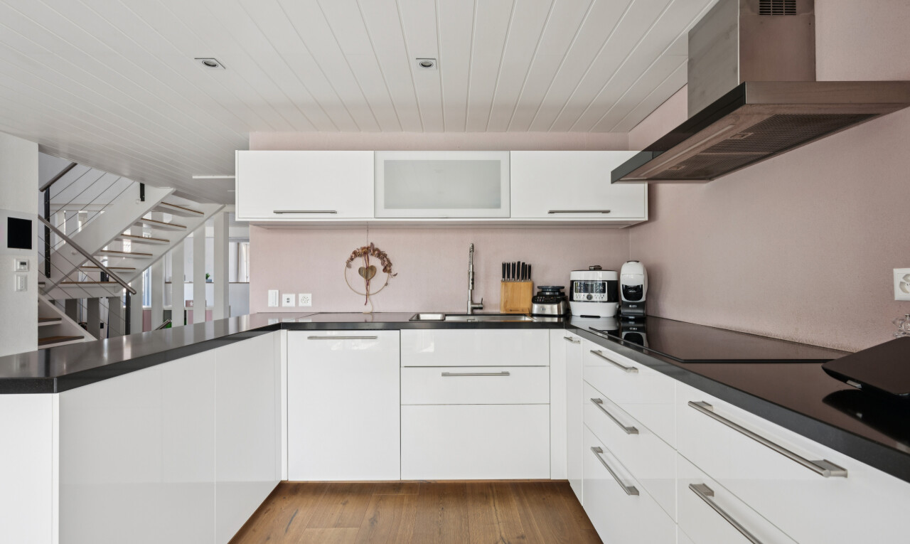 küche mit dunstabzugshaube, treppen, white cabinets, weiße schränke, und dark countertops