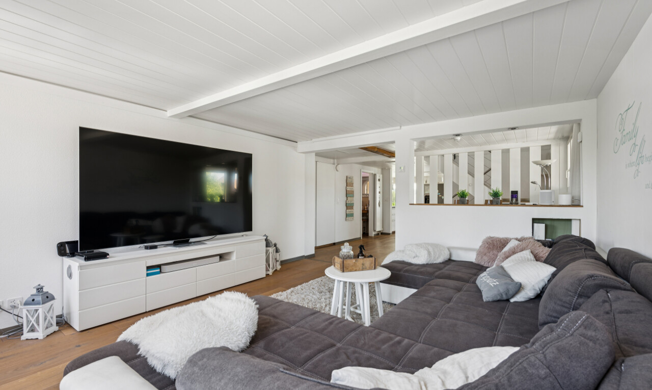 wohnzimmer mit fernseher, balkendecke, beamed ceiling, gipskartonwand, und drywall