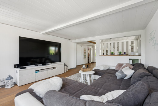 wohnzimmer mit fernseher, balkendecke, beamed ceiling, gipskartonwand, und drywall