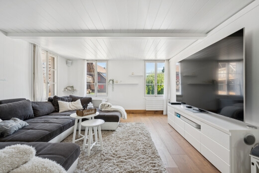 wohnzimmer mit natürliches licht, wood finish floor, holzfußboden, fernseher, und beamed ceiling