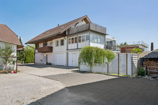 außenansicht mit auffahrt, eingebaute garage, day time, property visible, und stuckverkleidung