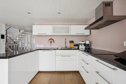 küche mit dunstabzugshaube, treppen, white cabinets, weiße schränke, und dark countertops