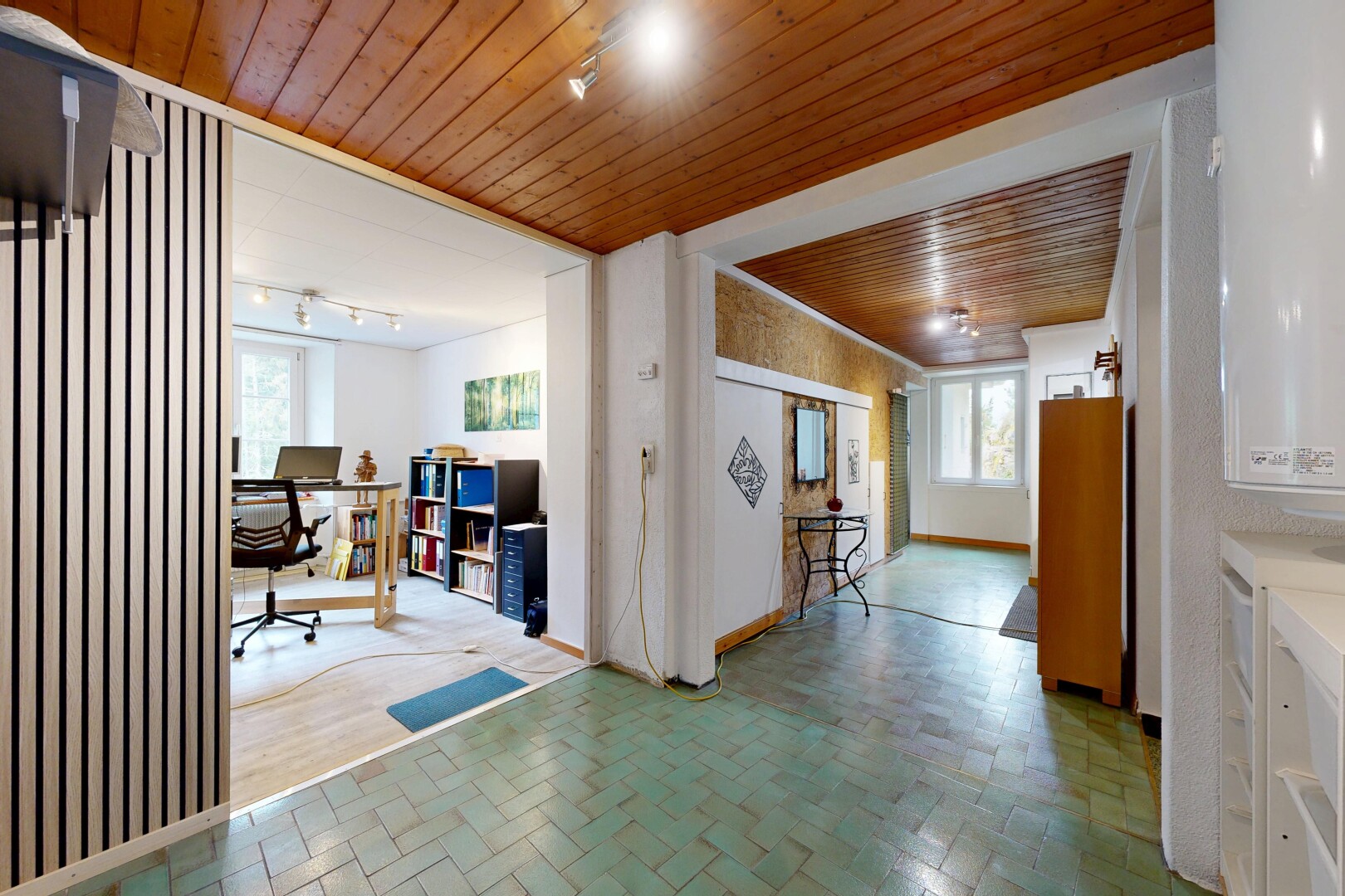corridor featuring wooden ceiling, an office area, and rail lighting