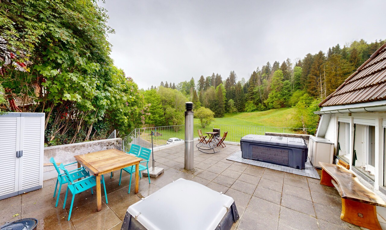 patio / terrace with a hot tub and outdoor dining area