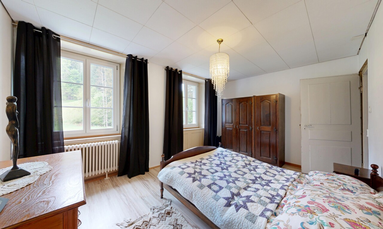 room featuring radiator heating unit, light wood finished floors, and suspended lighting