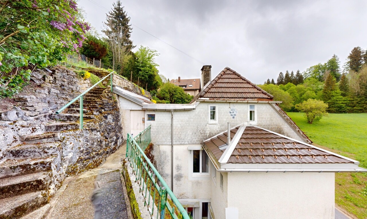 outdoor house featuring stucco siding and a chimney