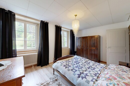 room featuring radiator heating unit, light wood finished floors, and suspended lighting