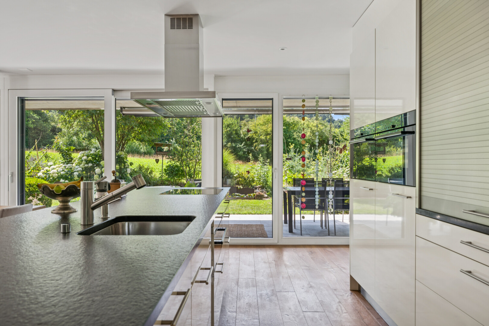 küche mit dunstabzugshaube, dark countertops, inside property, holzfußboden, und wood finish floor