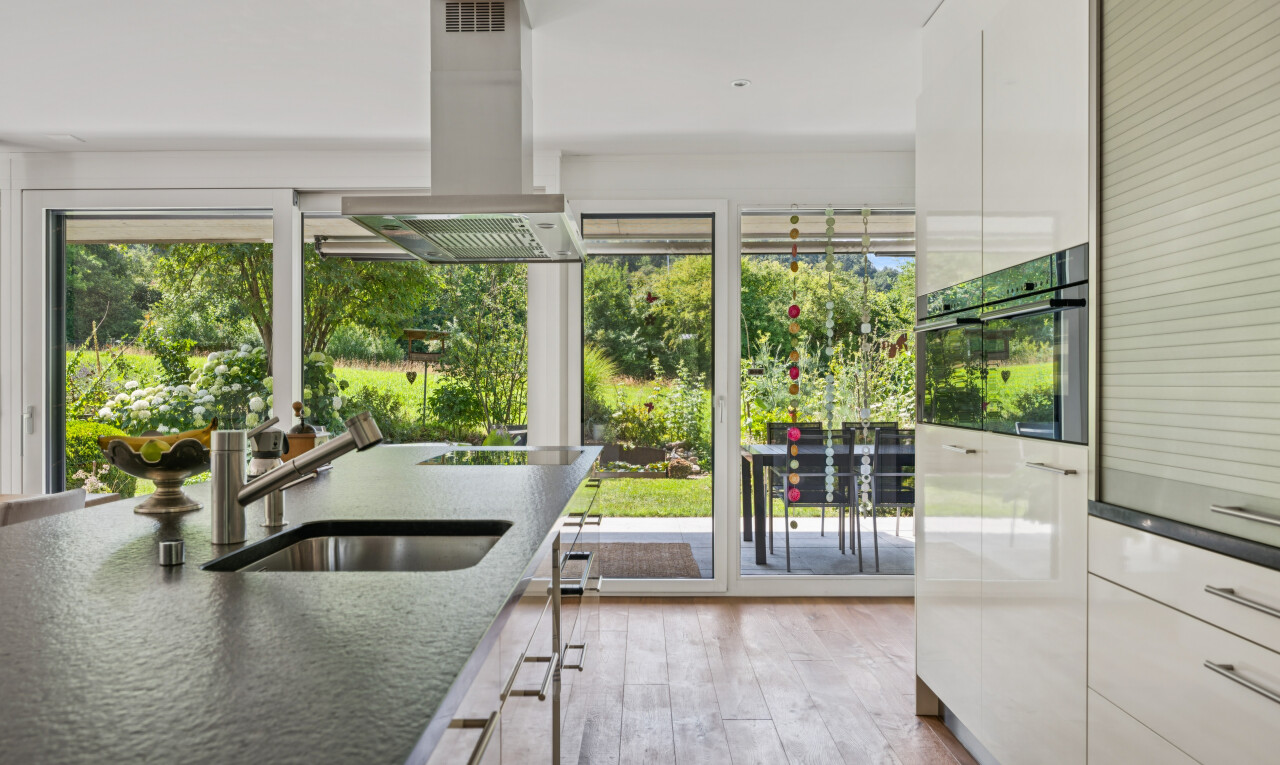 küche mit dunstabzugshaube, dark countertops, inside property, holzfußboden, und wood finish floor
