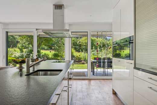 küche mit dunstabzugshaube, dark countertops, inside property, holzfußboden, und wood finish floor