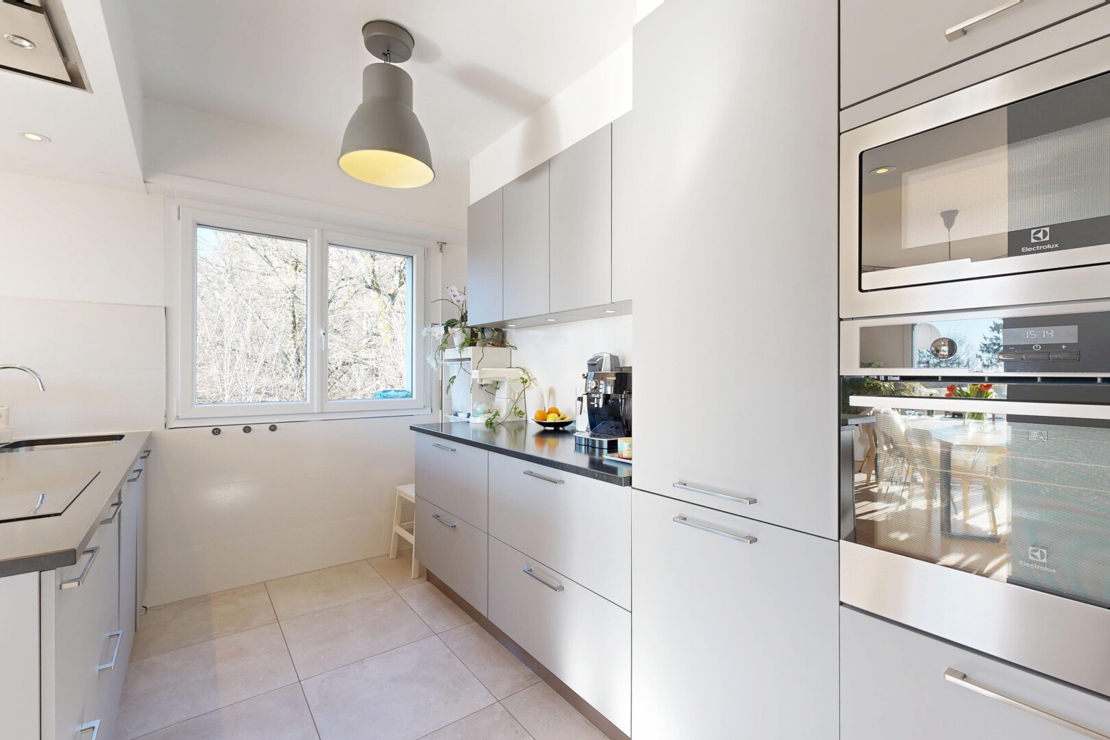 küche mit mikrowelle, ofen, inside property, schränke mit flachen paneelen, und natural light