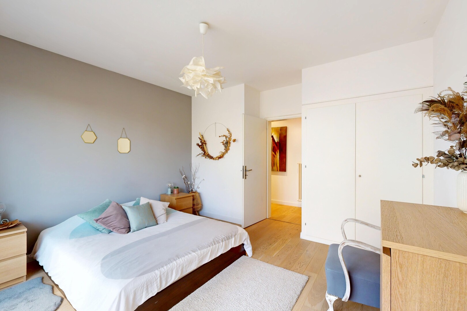 zimmer / schlafzimmer mit wood finish floor, holzfußboden, drywall, gipskartonwand, und bemerkenswerter kronleuchter