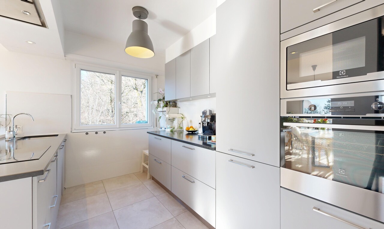 küche mit mikrowelle, ofen, inside property, schränke mit flachen paneelen, und natural light