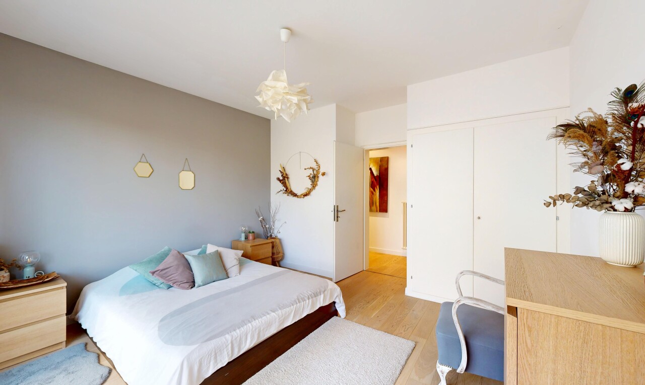 zimmer / schlafzimmer mit wood finish floor, holzfußboden, drywall, gipskartonwand, und bemerkenswerter kronleuchter