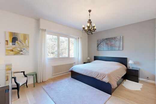 chambre avec wood finish floor, sol en finition bois, radiateur, drywall, et cloison sèche