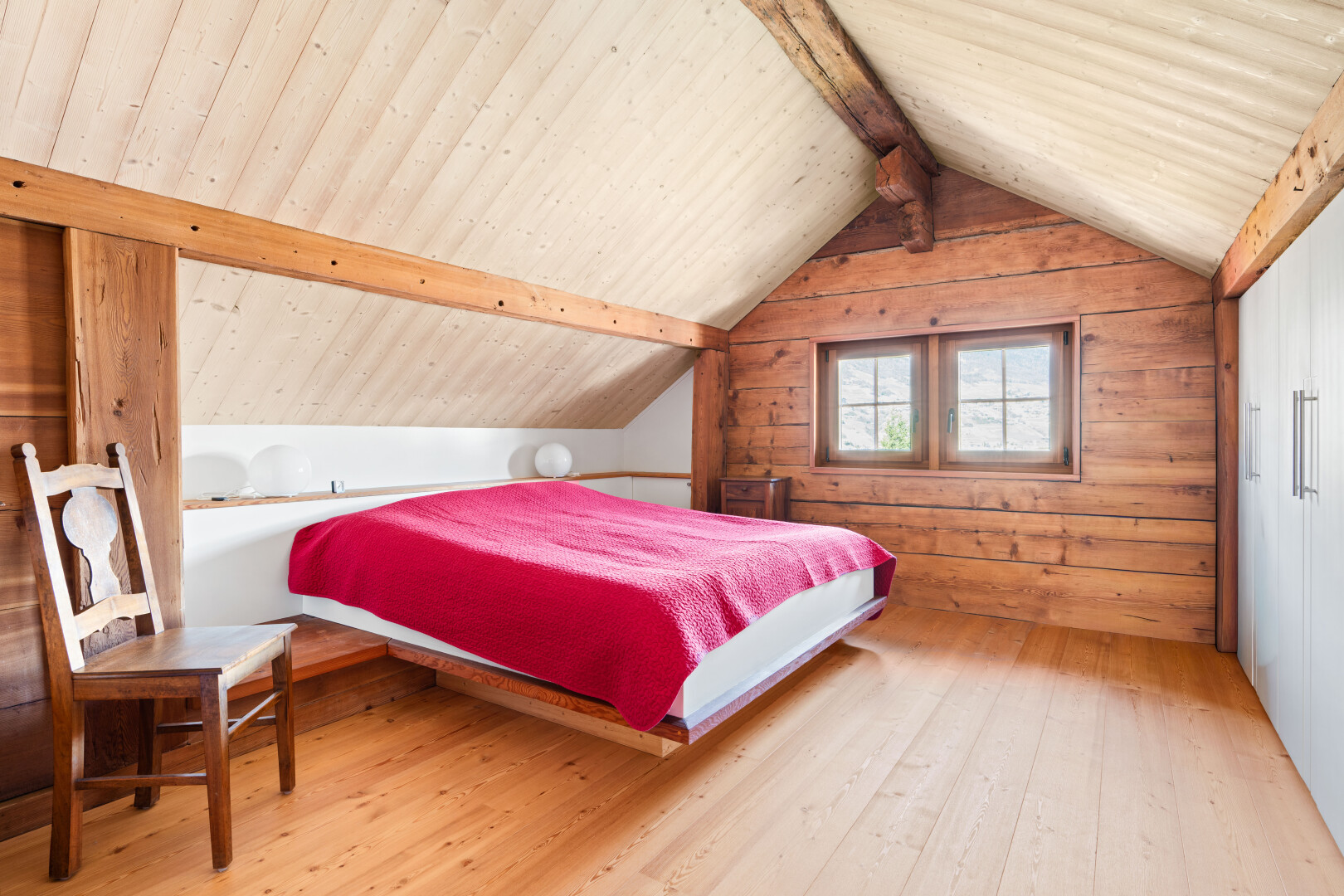 chambre avec pièce supplémentaire, sol en finition bois, wood finish floor, inside property, et mur en bois