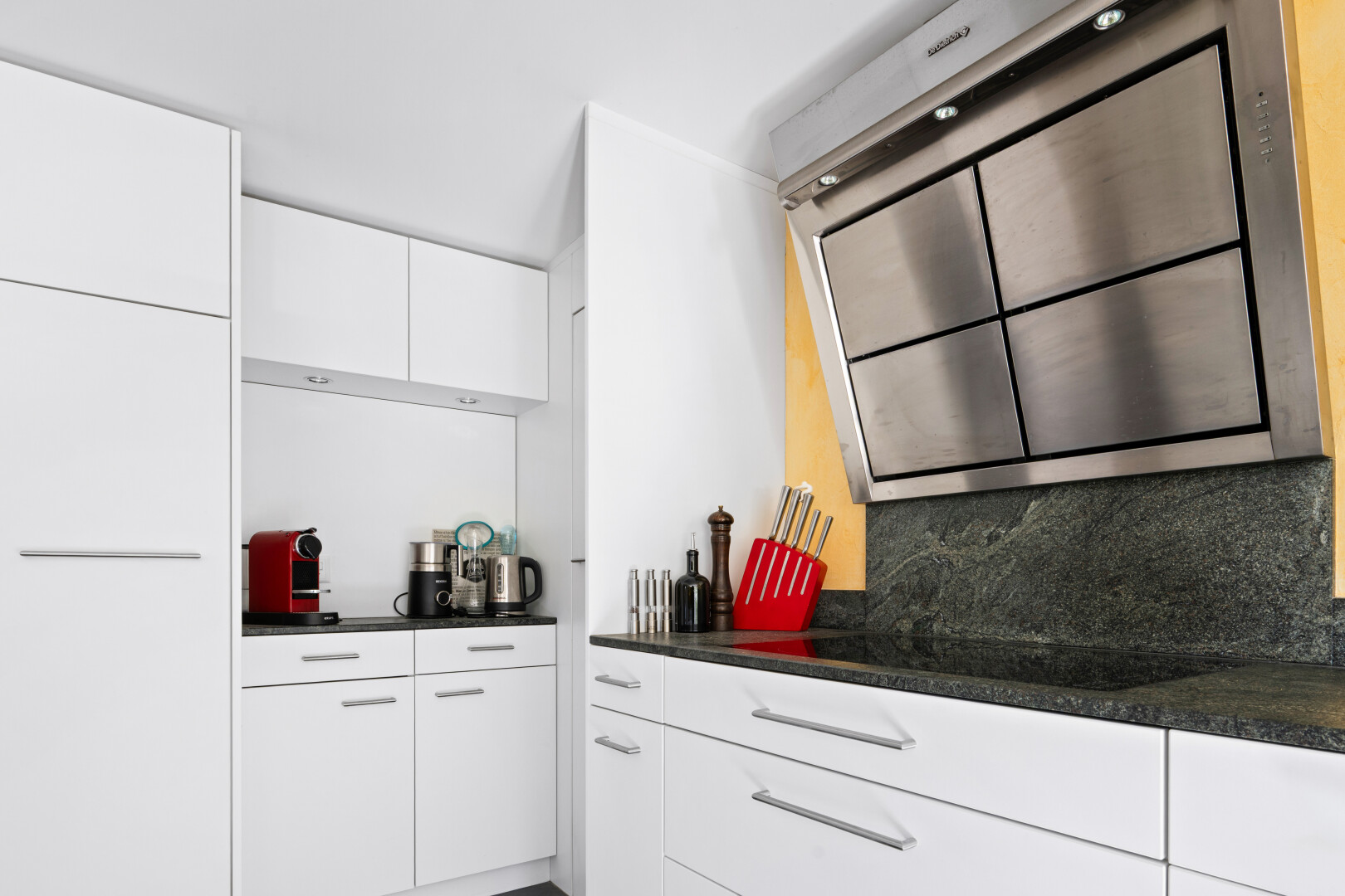 cuisine avec hotte, dark countertops, white cabinets, armoires blanches, et inside property