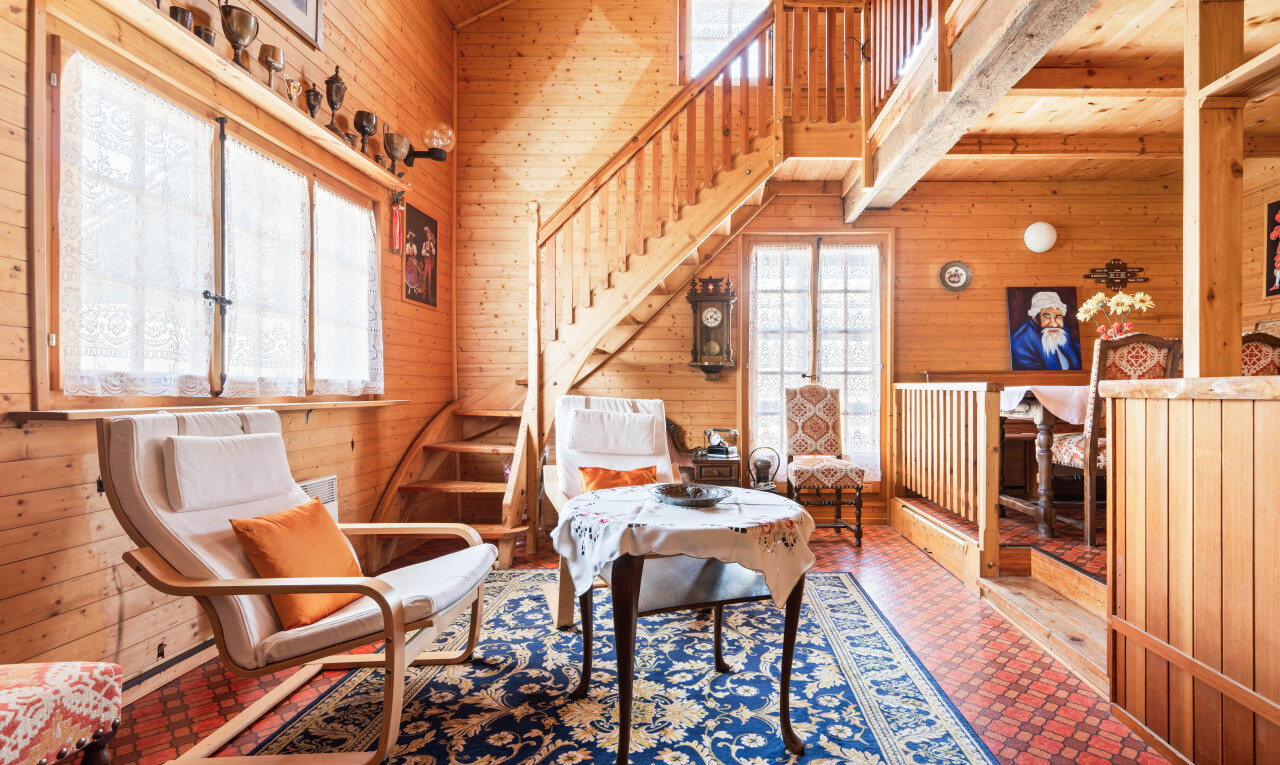 living area with wooden walls, lofted ceiling, and healthy amount of natural light
