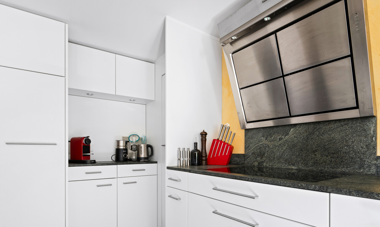 cuisine avec hotte, dark countertops, white cabinets, armoires blanches, et inside property
