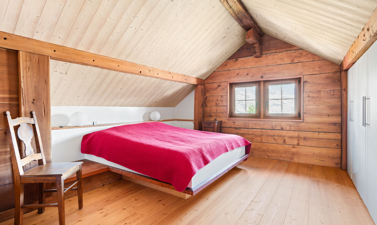 chambre avec pièce supplémentaire, sol en finition bois, wood finish floor, inside property, et mur en bois