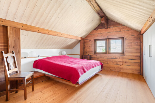 chambre avec pièce supplémentaire, sol en finition bois, wood finish floor, inside property, et mur en bois