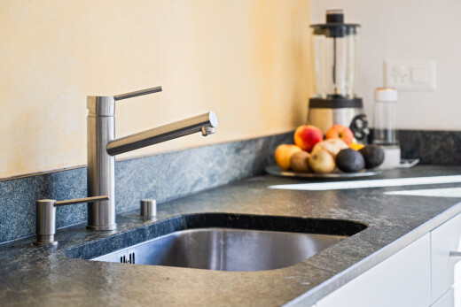 détails avec dark countertops, appliance, wall / siding, évier, et kitchen