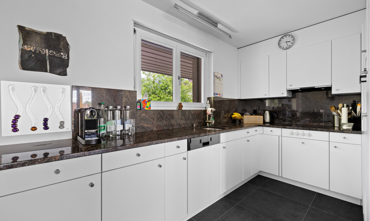kitchen featuring backsplash, white cabinetry, and dark tile patterned flooring