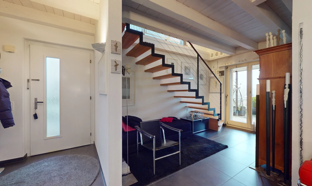 stairway featuring beam ceiling and dark tile flooring