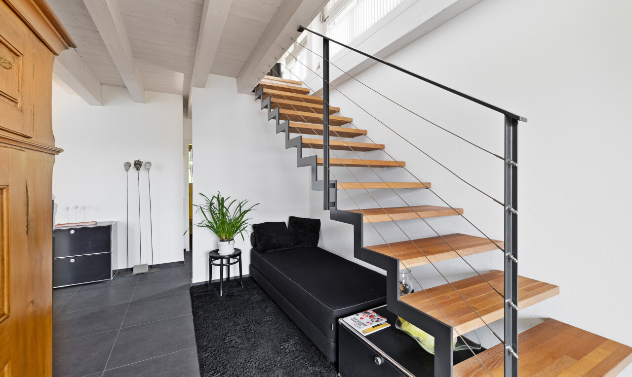 staircase with tile patterned flooring and beam ceiling