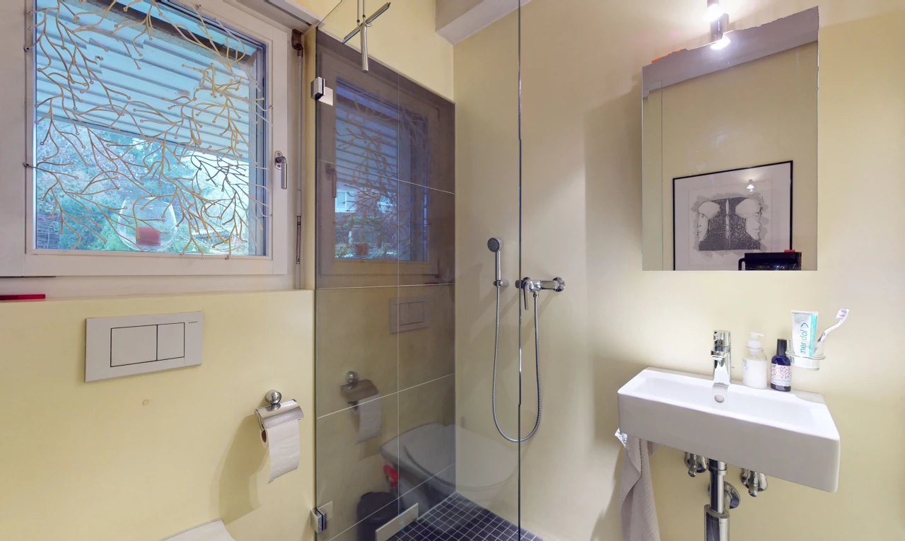 bathroom featuring toilet and a shower with door