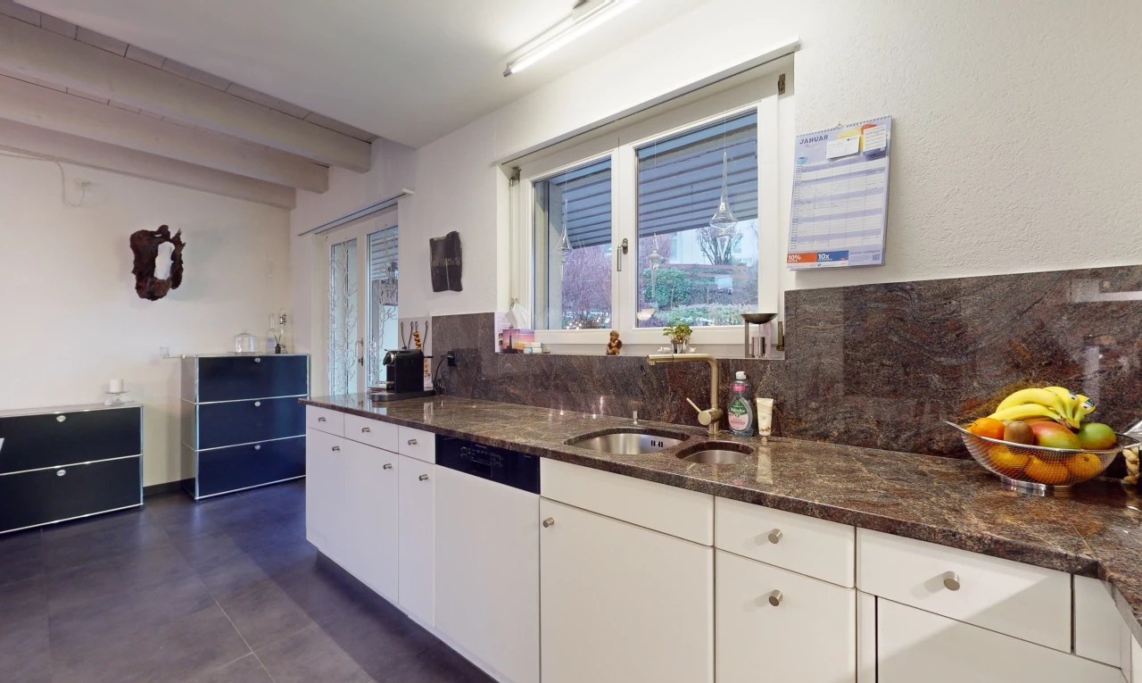 kitchen with dark stone countertops, white cabinets, dark tile flooring, sink, and tasteful backsplash