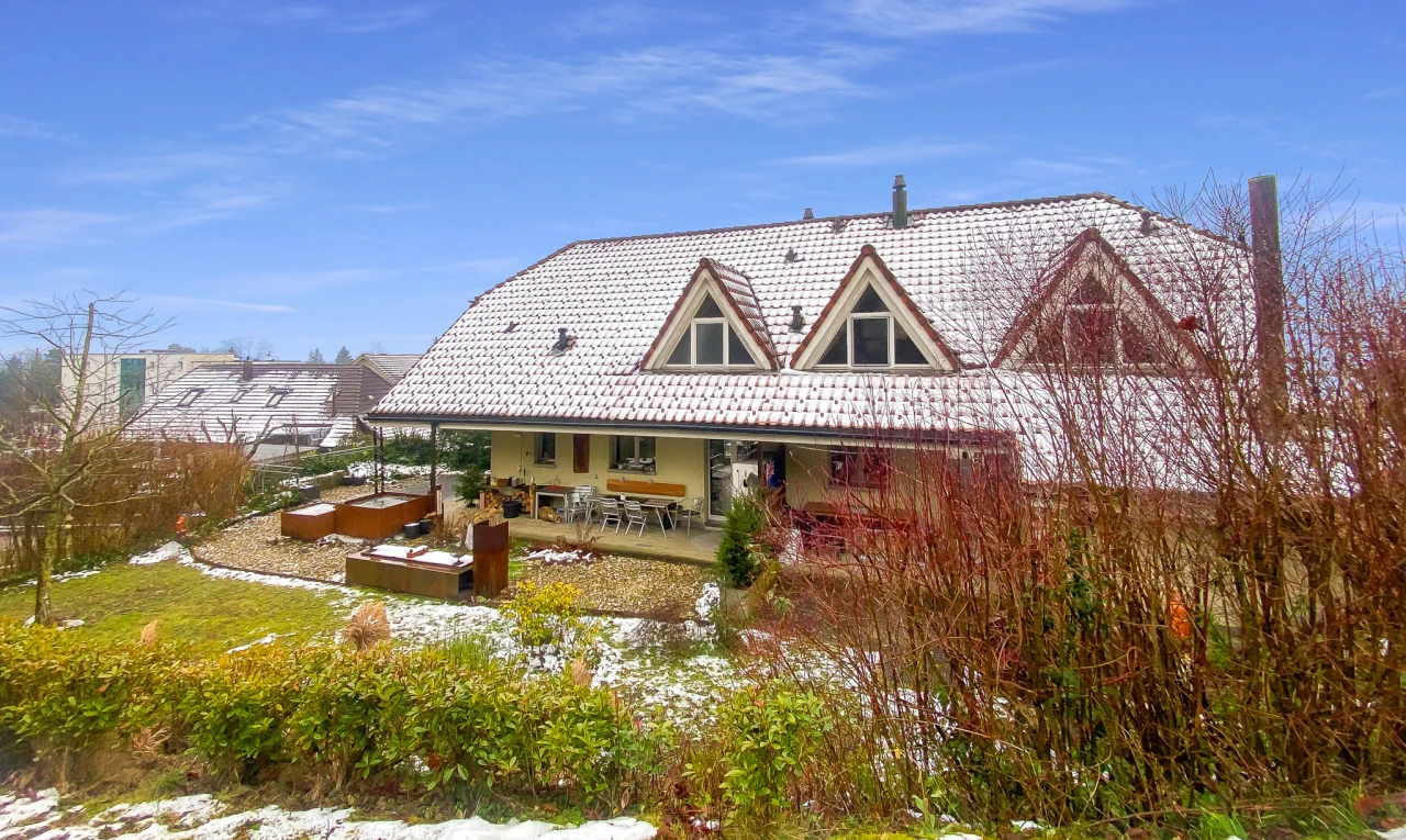 snow covered house with a patio