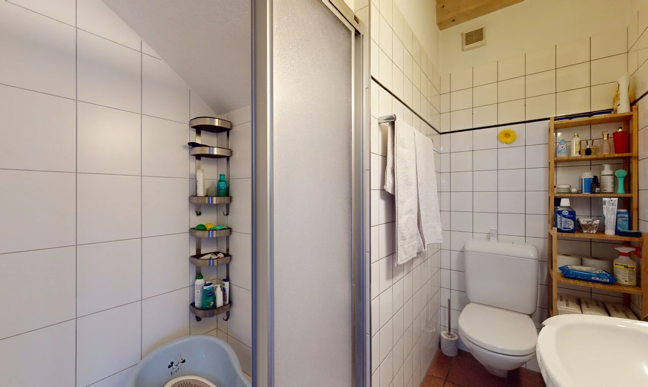 bathroom with tile walls, toilet, and lofted ceiling