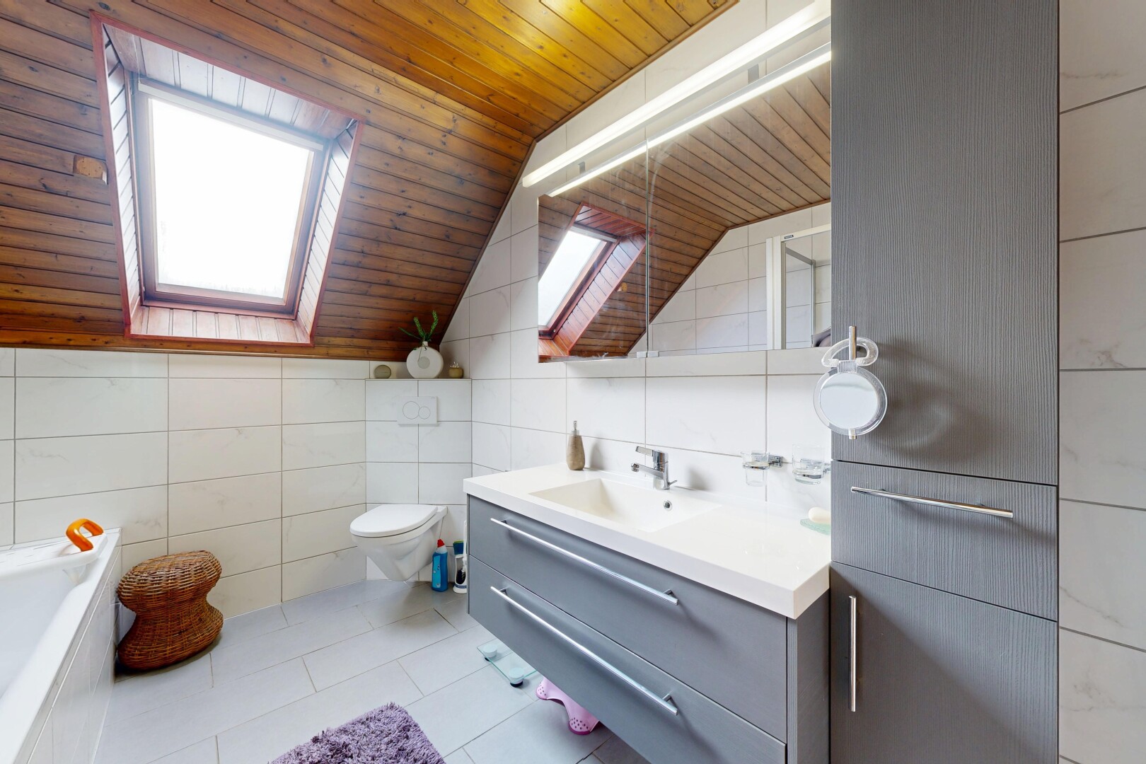 salle de bains avec miroir, mur en carrelage, tile wall, salle de bain complète, et plafond voûté