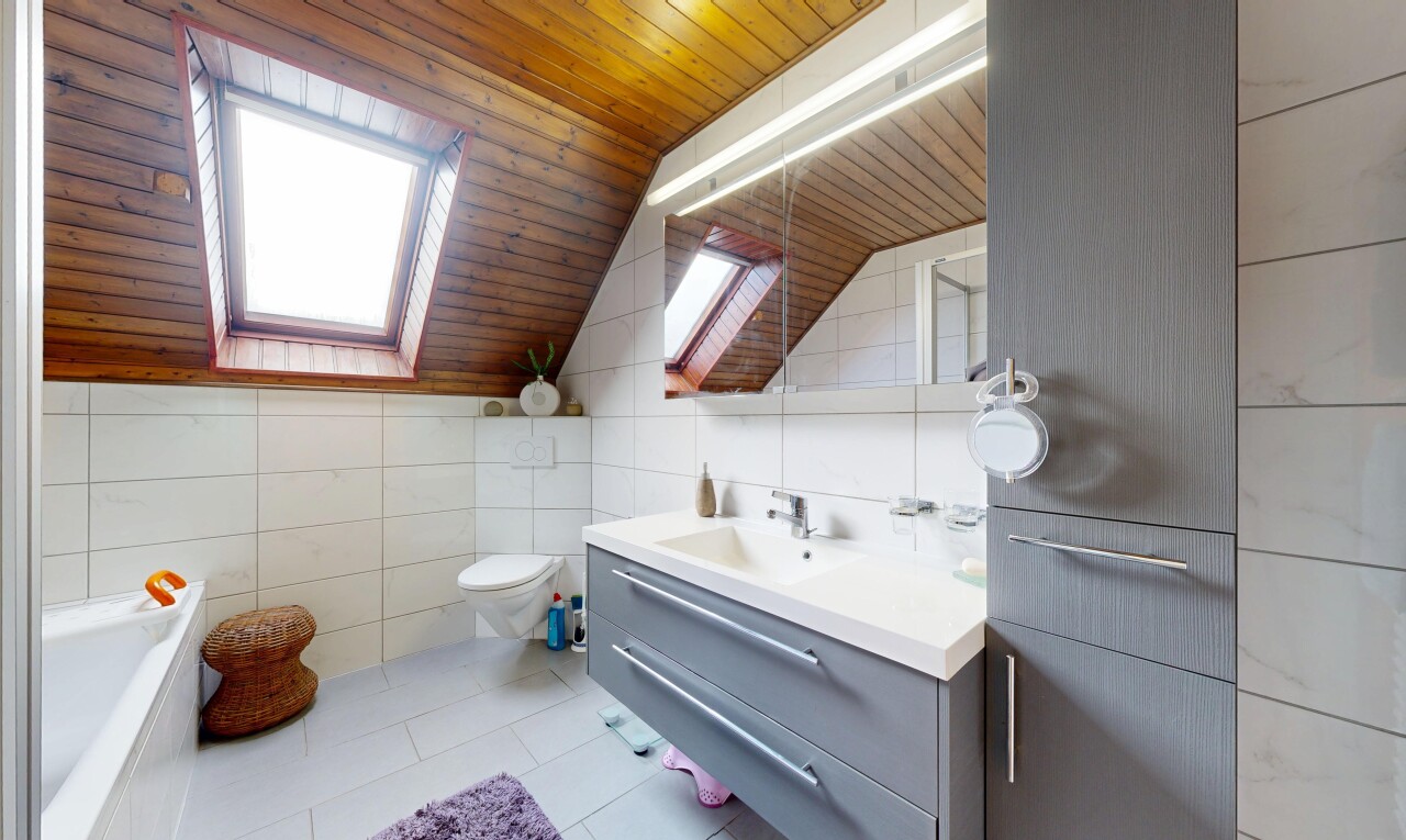 salle de bains avec miroir, mur en carrelage, tile wall, salle de bain complète, et plafond voûté