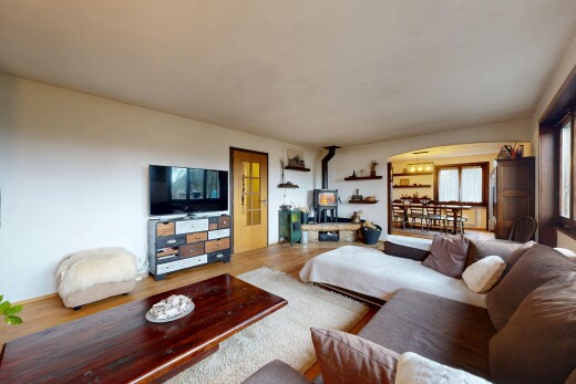 salon avec poêle à bois, télévision, cloison sèche, drywall, et inside property